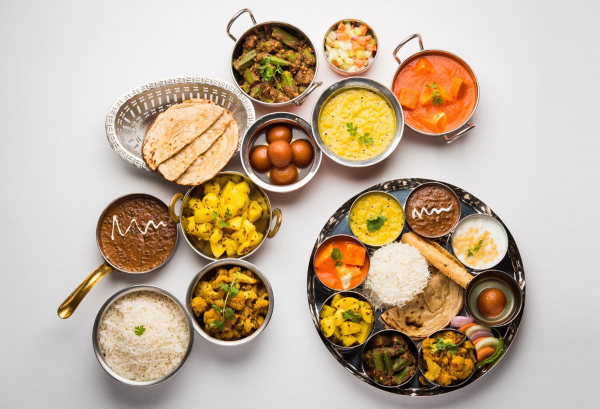 Vegetarian Thali set with vegetables, daal, rice, raita, sweets and curry