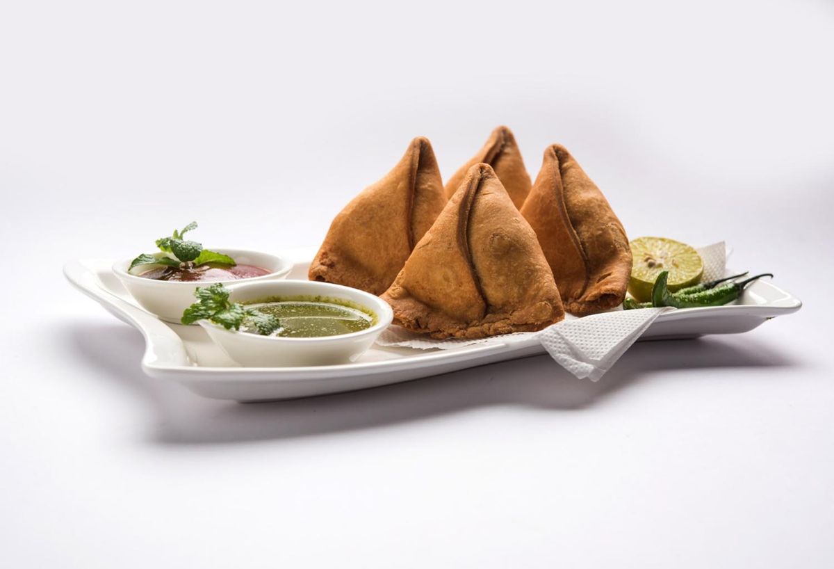 4 samosas in a plate with achar